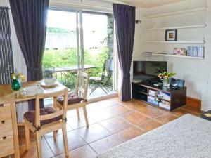 sala de estar con mesa y vistas a un balcón en Walker's Retreat, en Ambleside