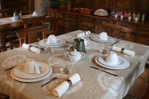 a table with white plates and glasses on it at Le Petit Coin De Maison Chante Lune in Introd