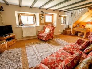 a living room with a couch and a tv at The Wilderness in Bromlow