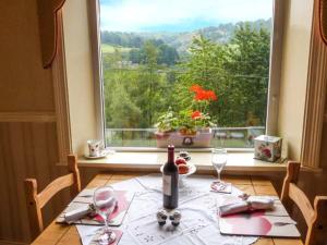 una mesa con una botella de vino y una ventana en Cottage in the Sky, en Luddenden Foot