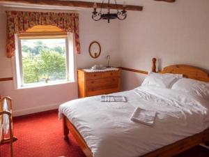Un dormitorio con una cama grande y una ventana en Cottage in the Sky, en Luddenden Foot