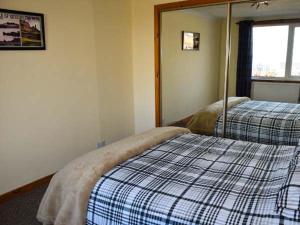 ein Schlafzimmer mit einem Bett und einem Spiegel darauf in der Unterkunft Amber's Cottage in Staffin