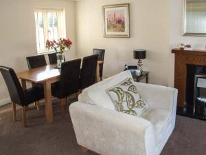 uma sala de estar com um sofá e uma mesa de jantar em Jubilee Mews em Andoversford