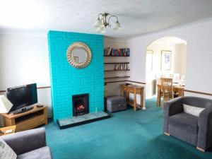 a living room with a fireplace with a blue brick wall at Off Puddle Hill in Stowe