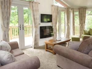 a living room with two couches and a television at Chaffinch Lodge in Highampton