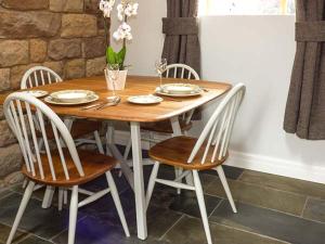 a wooden table with four chairs and a dining room at Herdwick's Barn in Wootton