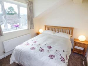 a bedroom with a white bed with flowers on it at Moorside in Horrabridge