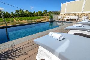 a pool with a table and chairs next to a swimming pool at סוויטת רגעים Regaim צימר בוטיק בגליל העליון in Sede Eli‘ezer