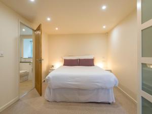 a bedroom with a white bed and a bathroom at Bishop's Castle Barn in Bishops Castle