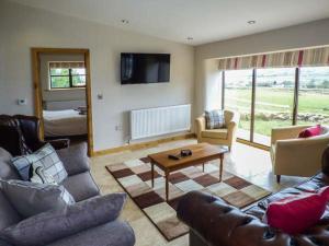 a living room with a couch and a coffee table at Upper Greenhills Farm in Foxt