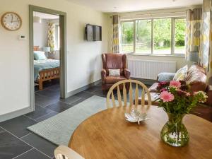 a living room with a table with a vase of flowers on it at The Lodge, Lower Trefedw in Pandy