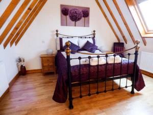 a bedroom with a black bed with purple pillows at The Barn Ivy Cottage in Dunnington