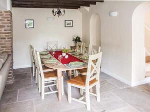 a dining room with a red table and chairs at Ganarew Cottage in Whitchurch