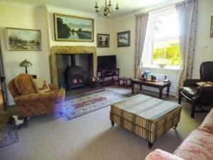 a living room with a fireplace and a couch at New House in Bewcastle