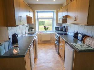 a kitchen with a sink and a stove top oven at Pensychnant Cottage in Conwy