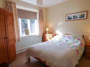 a bedroom with a bed and a window at Pensychnant Cottage in Conwy