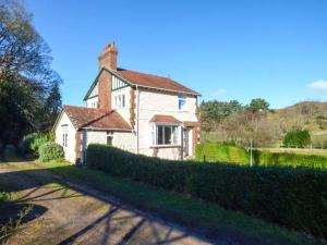 a large white house with a chimney on a street at Pensychnant Cottage in Conwy