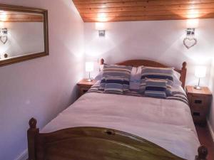 a bedroom with a bed with pillows and a mirror at Bod Rhiw in Llandegwning