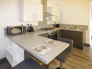 una cucina con un piano di lavoro con un forno a microonde di White Cottage Annexe a Tenby