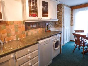 a kitchen with a washing machine in a kitchen at Sandy Knowes in Amble