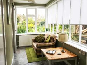 a living room with a couch and a table at Dermot Cottage in Gatehouse of Fleet