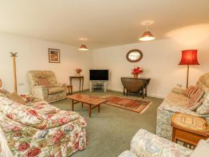 a living room with couches and a tv at West Bowden Farm in Knowstone