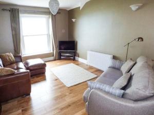a living room with a couch and a chair at Sea View Apartment in Llanfairfechan