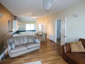 a living room with a couch and a kitchen at Sea View Apartment in Llanfairfechan