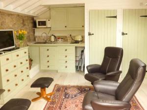 a living room with two chairs and a kitchen at Beech View in Malton