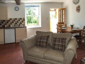 a living room with a couch and a kitchen at Cotswold View in Shottery