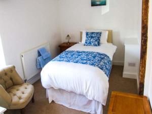 sypialnia z dużym łóżkiem i krzesłem w obiekcie Cotswold View w mieście Shottery