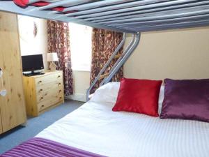 ein Schlafzimmer mit einem Etagenbett mit roten und violetten Kissen in der Unterkunft Seagull's Rest in Ramsgate