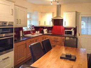a kitchen with a wooden table and a stove top oven at Laurel Cottage in Leadgate