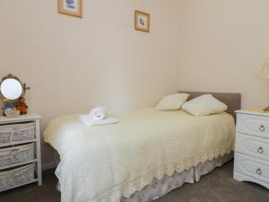 a bedroom with a bed and a dresser and a mirror at Spurling Cottage in Cheveley