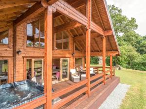 a large wooden house with a hot tub at Hampton Lodge in Penley