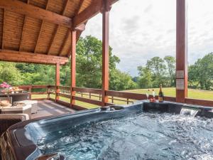 an outdoor hot tub on a deck with a pavilion at Hampton Lodge in Penley