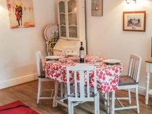 a dining room with a table with a bottle of wine at St Margaret's Cottage in Chardstock
