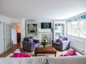 a living room with a couch and two chairs and a table at 4 The Nab House in Bembridge