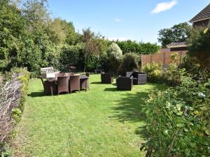 a garden with a table and chairs in the grass at 4 The Nab House in Bembridge