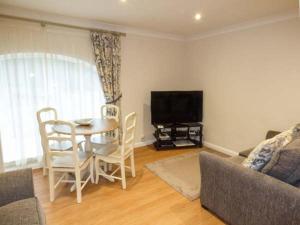 uma sala de estar com uma mesa e uma televisão em Walworth Castle Holiday Cottage em Walworth