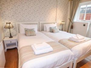 2 camas individuales en un dormitorio con 2 lámparas en Walworth Castle Holiday Cottage en Walworth