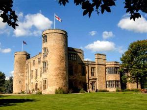 a castle with two flags on top of it at Walworth Castle Holiday Cottage in Walworth