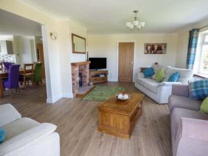 a living room with a couch and a table at Bryn Tirion in Bettws-yn-Rhôs