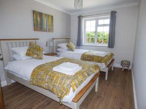 ein Schlafzimmer mit zwei Betten und einem Fenster in der Unterkunft Bryn Tirion in Bettws-yn-Rhôs