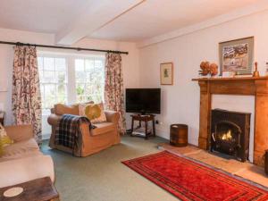 a living room with a couch and a fireplace at Townhead Farmhouse in Patterdale