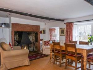 a living room with a table and chairs and a fireplace at Townhead Farmhouse in Patterdale