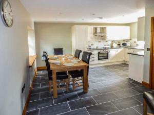 a kitchen with a wooden table and black chairs at Bank Top in Earl Sterndale