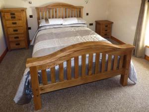 a bedroom with a wooden bed and a dresser at Bank Top in Earl Sterndale