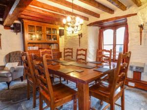a dining room with a wooden table and chairs at Yr Hen Felin in Carrog