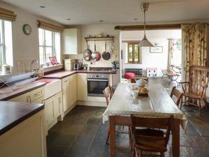 a kitchen with a table and chairs in a kitchen at Gatehouse in Painscastle